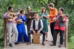 Ein Musikensemble steht musiziert gemeinsam in einem Park