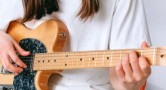 Mädchen spielt an einer E-Gitarre