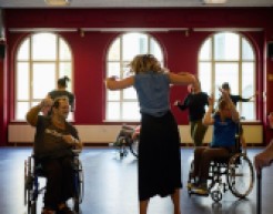 Menschen tanzen mit und ohne Behinderung in einem Raum